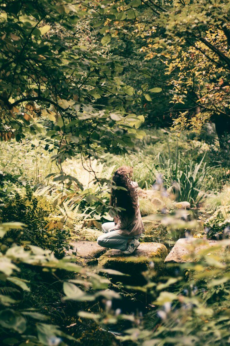 Woman in a serene forest setting surrounded by lush greenery in Hamburg, Germany.